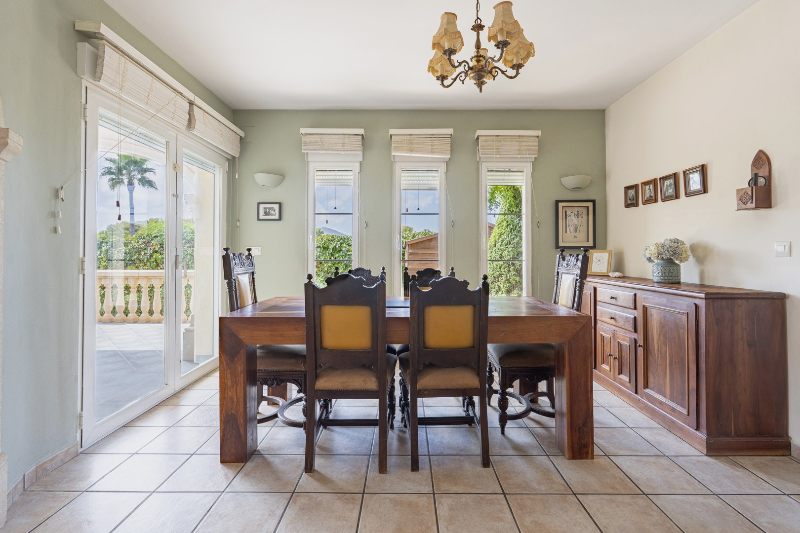 Helles Esszimmer mit Massivholztisch, passendem Sideboard und Zugang zu einer Außenterrasse.