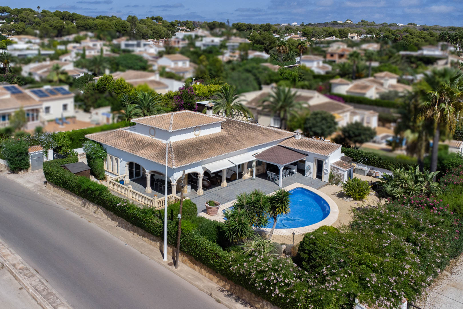Luftaufnahme einer Villa mit privatem Pool, überdachter Terrasse und gepflegtem Garten in Costa Nova, Jávea.