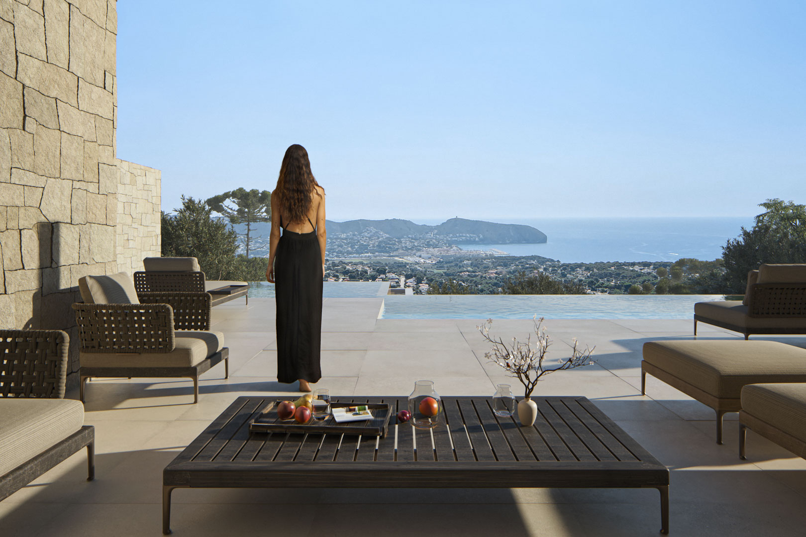 Außenterrasse mit Designer-Loungemöbeln, Natursteinwand und Infinity-Pool mit Panoramablick auf das Mittelmeer und die Küste von Moraira.