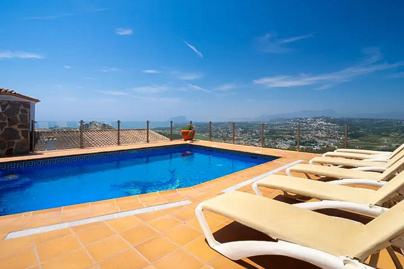 Außenpool mit griechischer Mosaikborte, Terrakotta-Sonnenterrasse mit Liegen und Glasgeländer mit Panoramablick auf das Mittelmeer und Moraira.