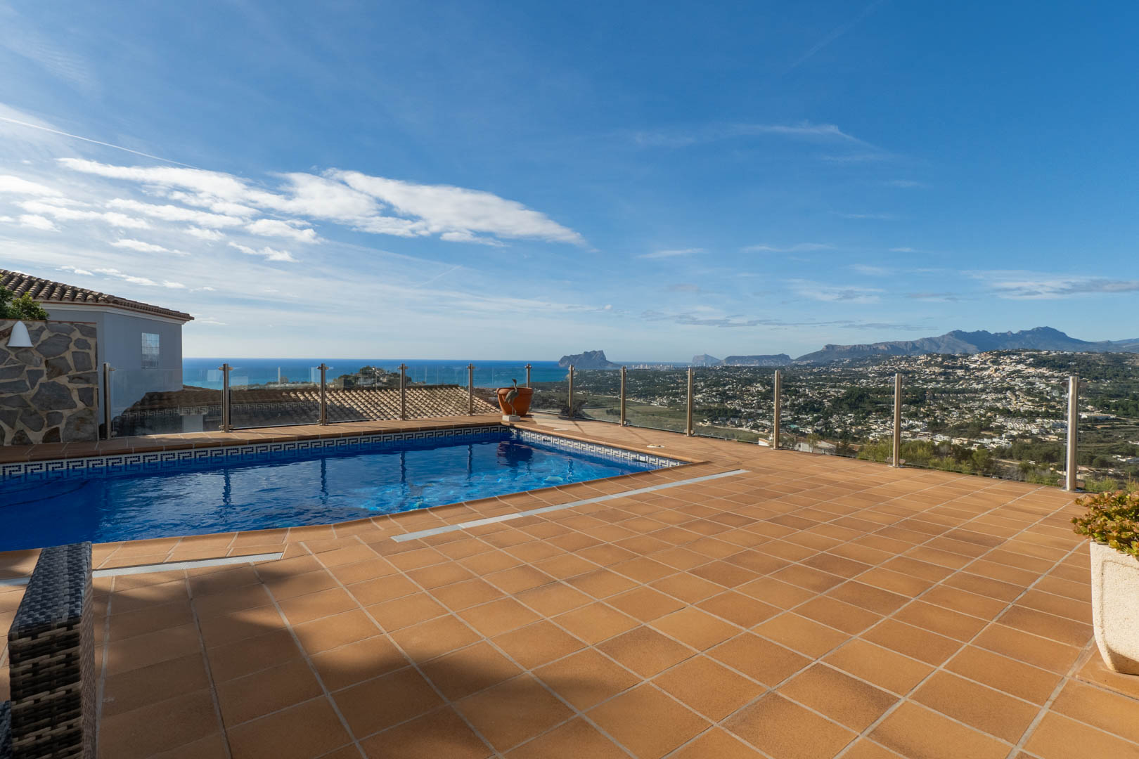 Terracotta-Terrasse mit privatem Pool und Glasgeländer, die einen freien Panoramablick auf das Mittelmeer und den markanten Peñón de Ifach bietet.