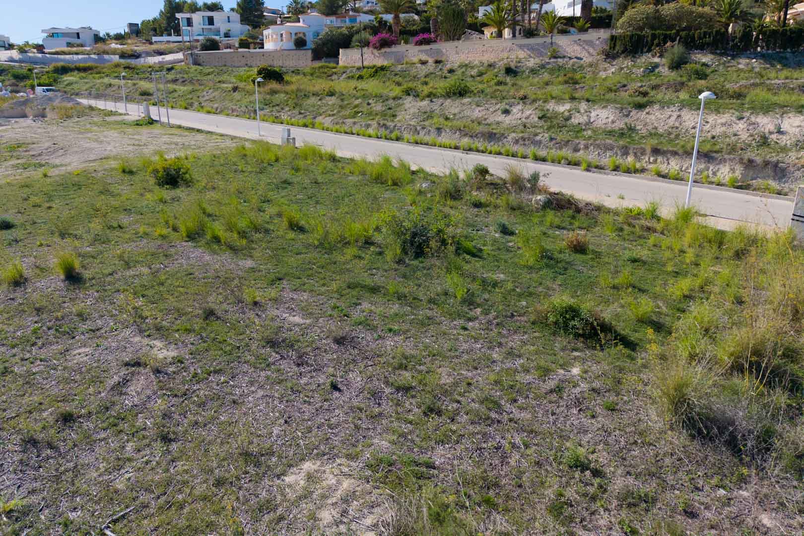 Ebenes Stadtgrundstück mit direktem Zugang über eine asphaltierte Straße und Straßenbeleuchtung im wachsenden Wohngebiet El Tesoro.
