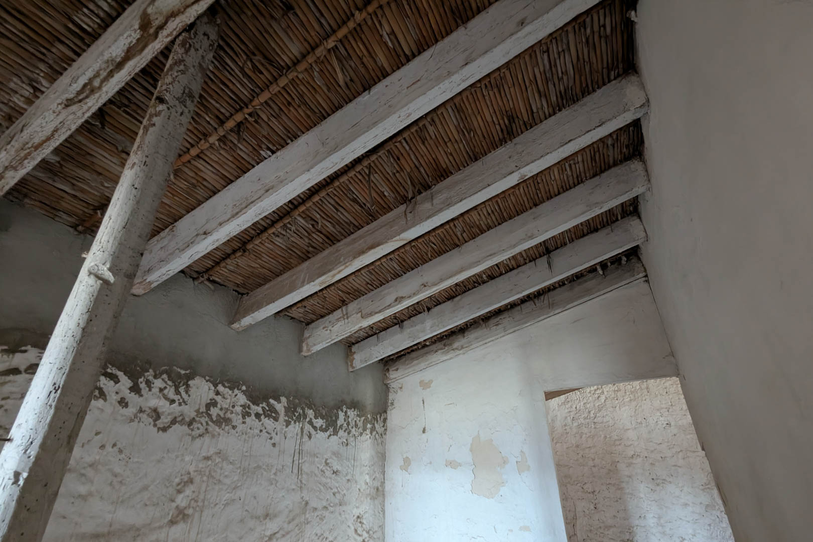 Innenansicht der originalen Schilfrohrdecke und der kalkgebleichten Holzbalken. Die Natursteinwände bewahren ihre traditionelle Kalkbeschichtung.