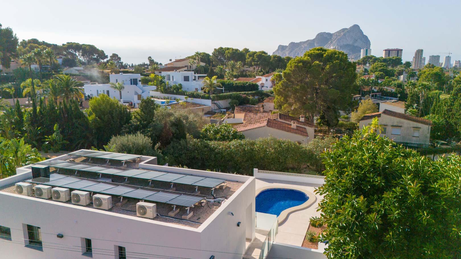 Luftaufnahme mit der Photovoltaikanlage auf dem Dach, dem privaten Pool und dem Panoramablick auf den markanten Peñón de Ifach in Calpe.