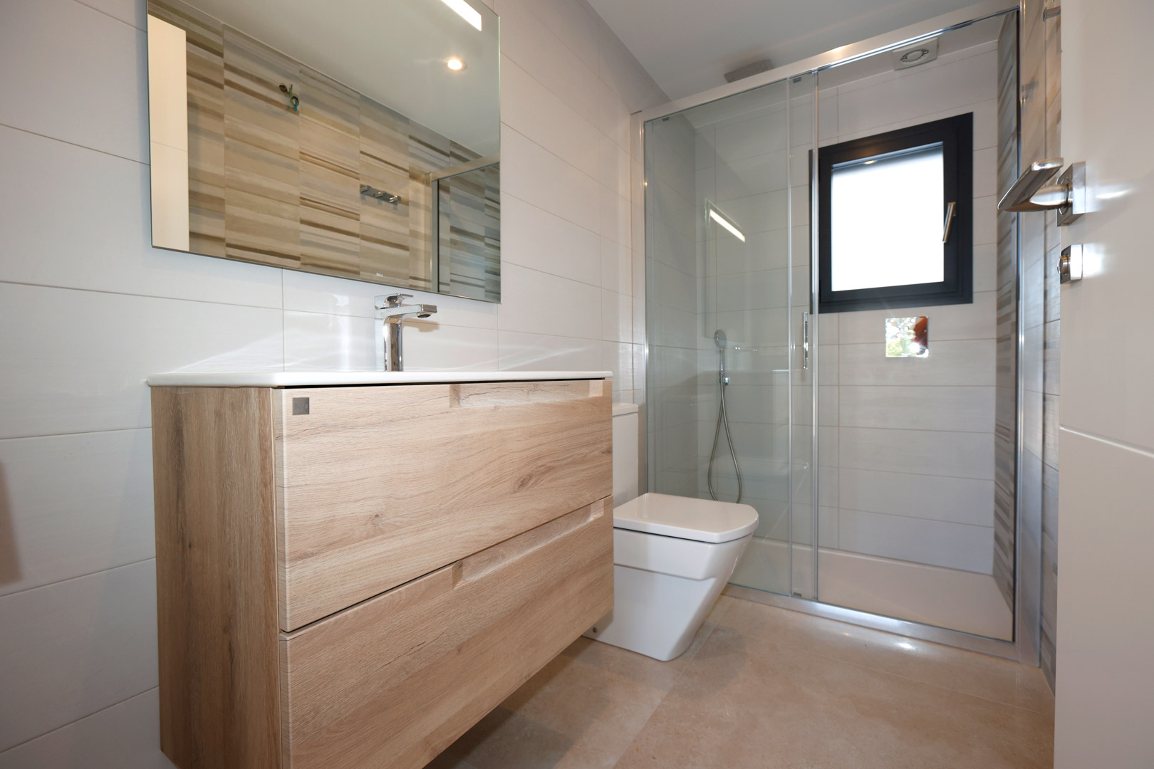 Modernes Badezimmer mit Holz-Waschtisch, Glasduschwand und weißen Fliesen. Ausgestattet mit Feinsteinzeugboden und einem Fenster mit schwarzem Rahmen.