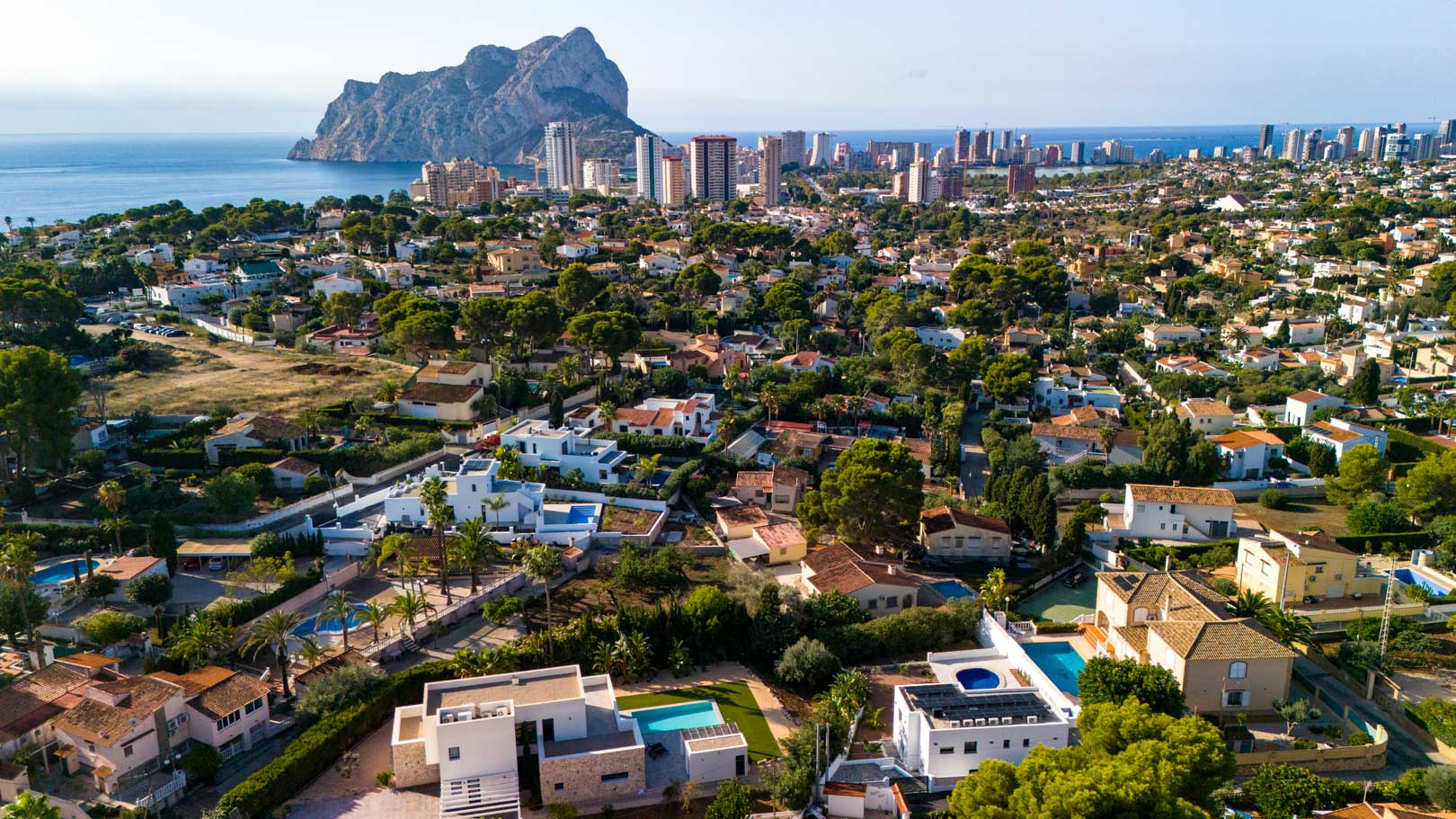 Panorama-Luftaufnahme der Villa in Calpe mit Photovoltaikanlage auf dem Dach und freiem Blick auf den Peñón de Ifach und das Mittelmeer.