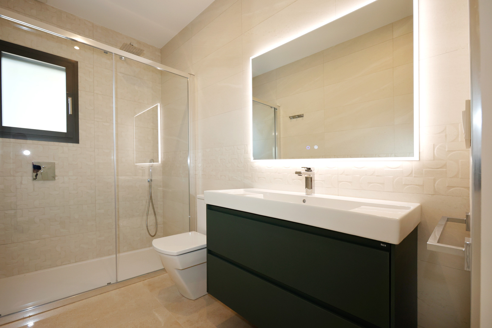 Zeitgenössisches Badezimmer mit anthrazitfarbenem Waschtisch, Roca-Becken und LED-Spiegel. Mit Glasduschwand und strukturierten Feinsteinzeugfliesen an den Wänden.