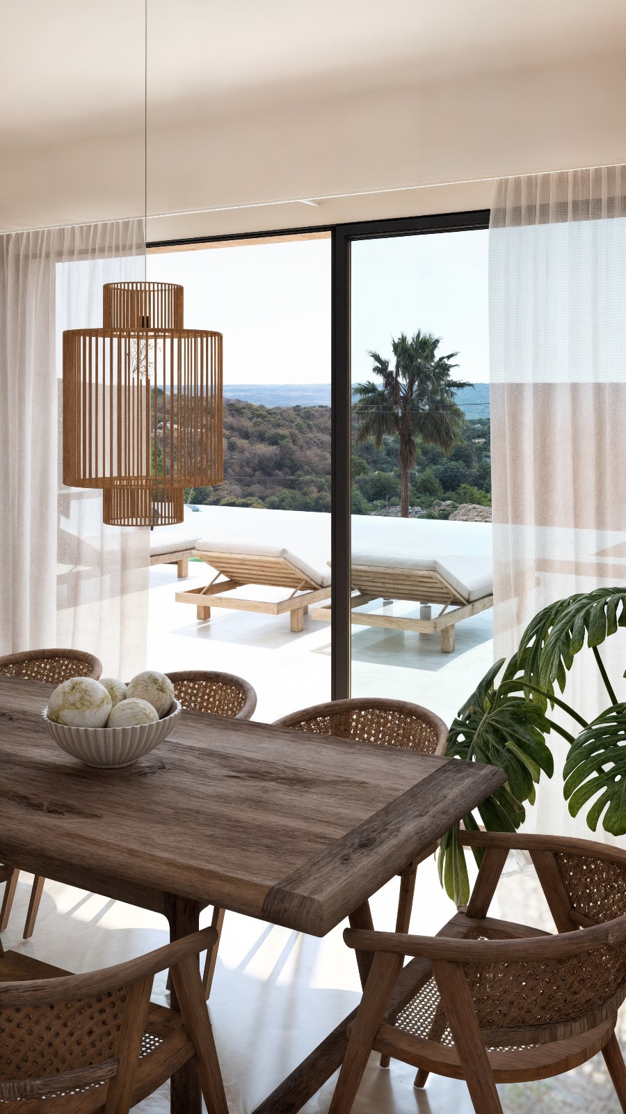 Essbereich mit Massivholztisch und Holzlamellen-Pendelleuchte, mit Blick auf die Terrasse, den Infinity-Pool und das Mittelmeer durch bodentiefe Fenster.