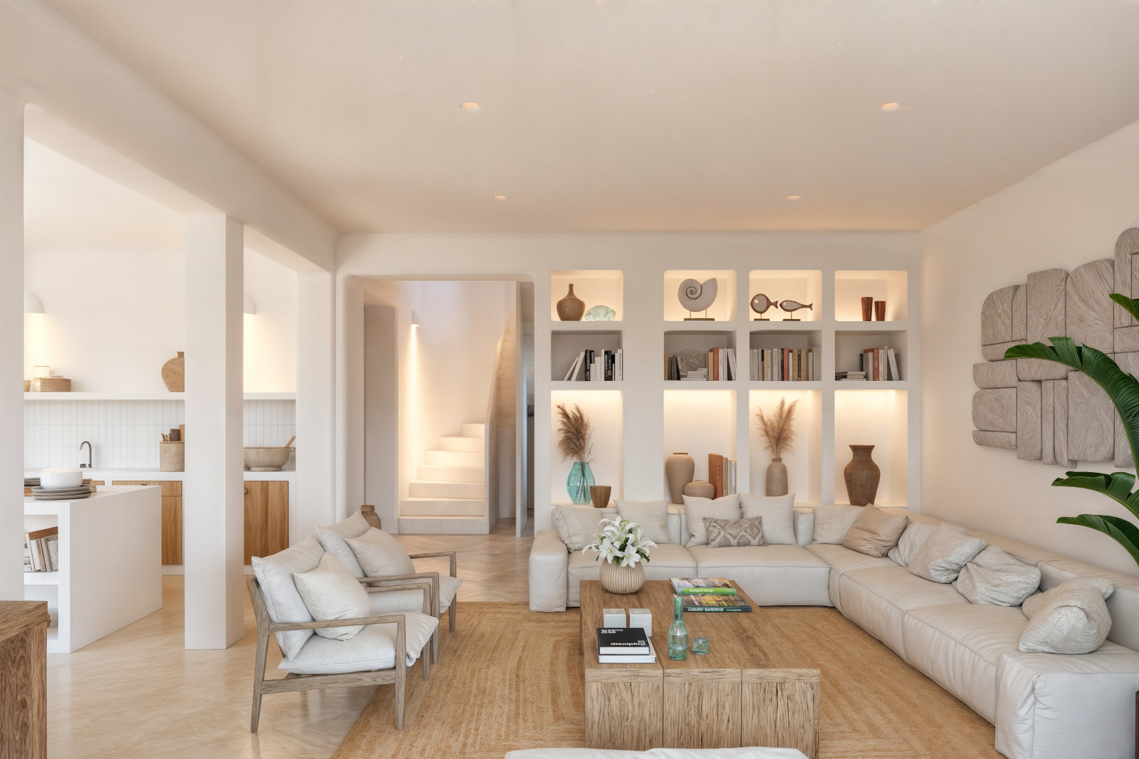 Wohnzimmer im ibizenkischen Stil mit beleuchteten Einbauregalen, großem Ecksofa und Massivholztisch auf einem Naturfaserteppich. Im Hintergrund ist die Treppe sichtbar.