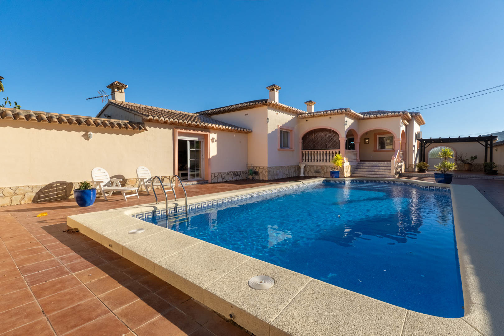 Großzügiger Außenbereich mit privatem Pool, Terrakotta-Sonnenterrasse und einer überdachten Naya mit mediterranen Rundbögen.
