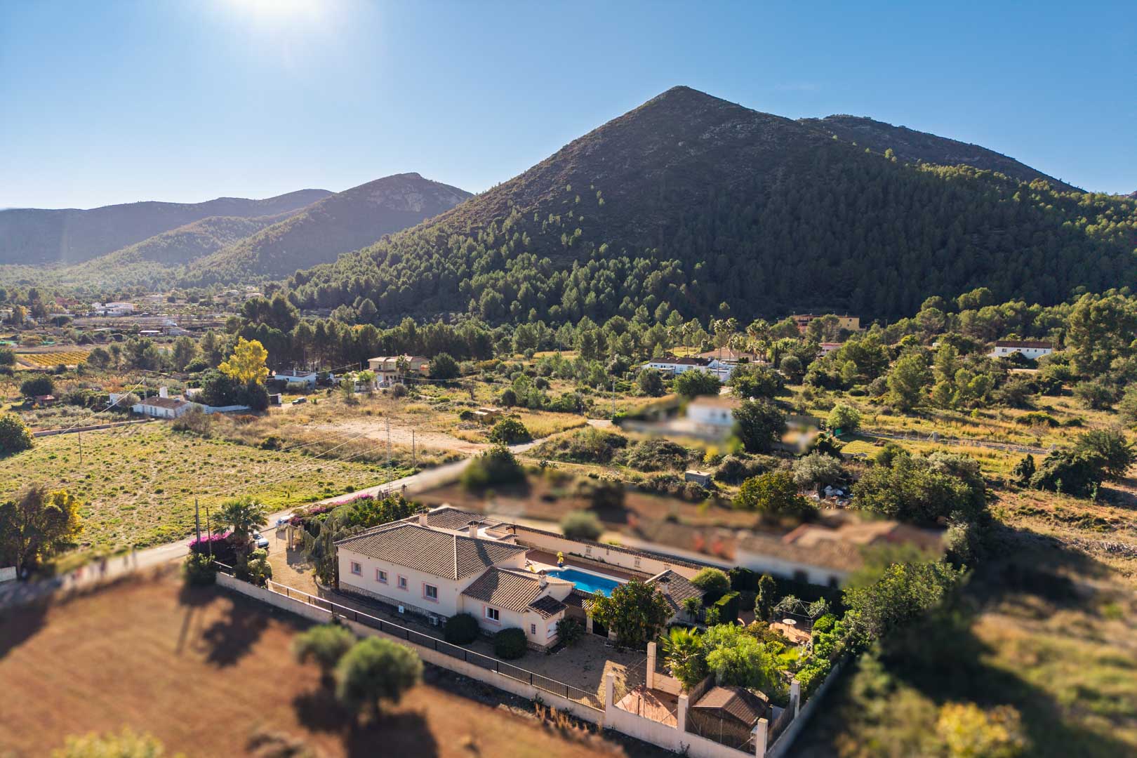 Luftaufnahme der mediterranen Villa in Jalón mit privatem Poolbereich und weitem Blick auf die umliegende, bewaldete Berglandschaft.