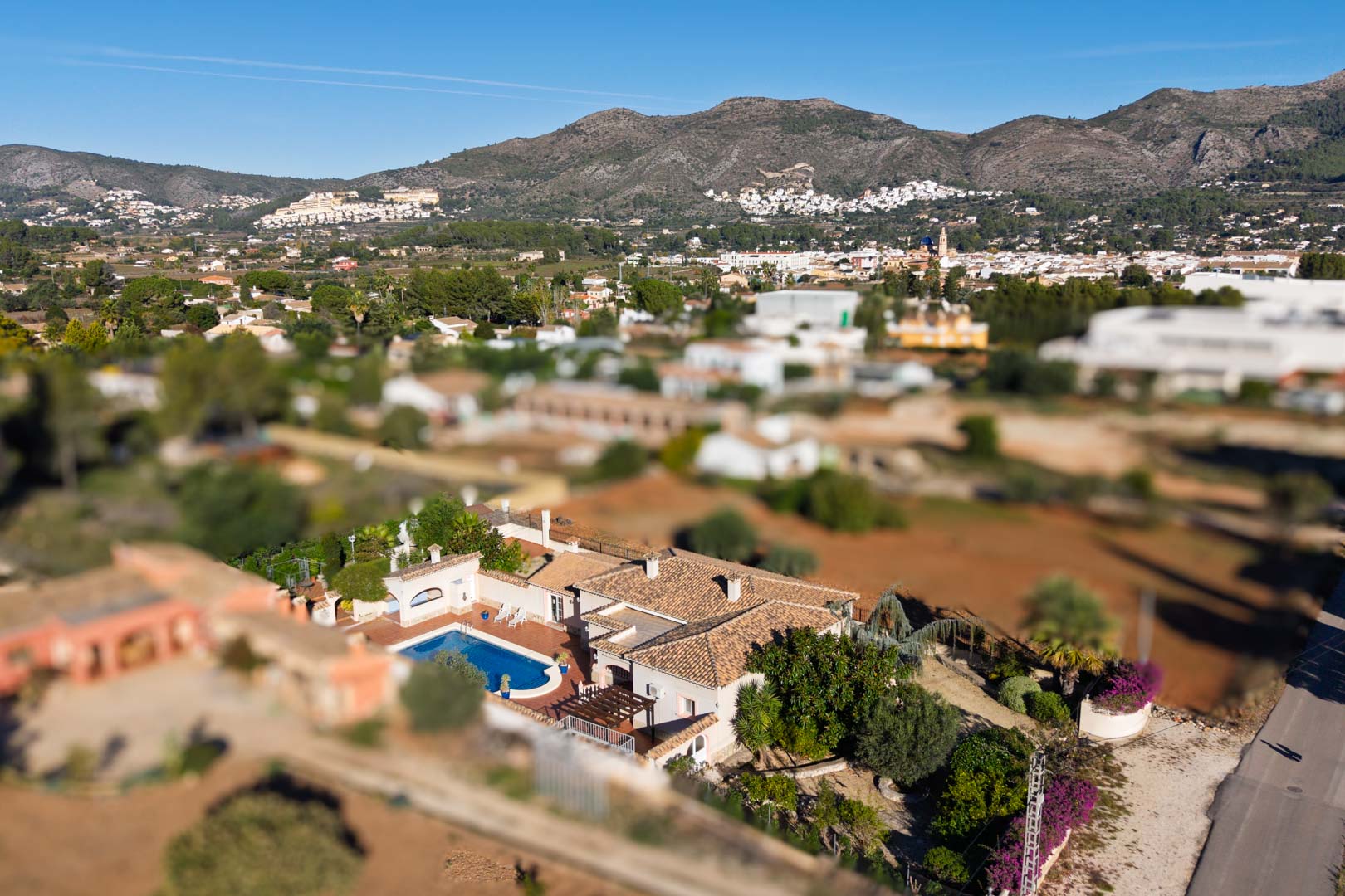 Luftbild der mediterranen Villa mit Pool und Ziegeldach, eingebettet in die Landschaft von Jalón mit weitem Blick auf die umliegenden Berge.