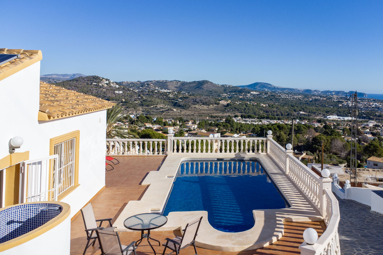 Außenterrasse mit Swimmingpool, klassischer Balustrade und Panoramablick auf die Küste von Calpe und die umliegenden Berge.
