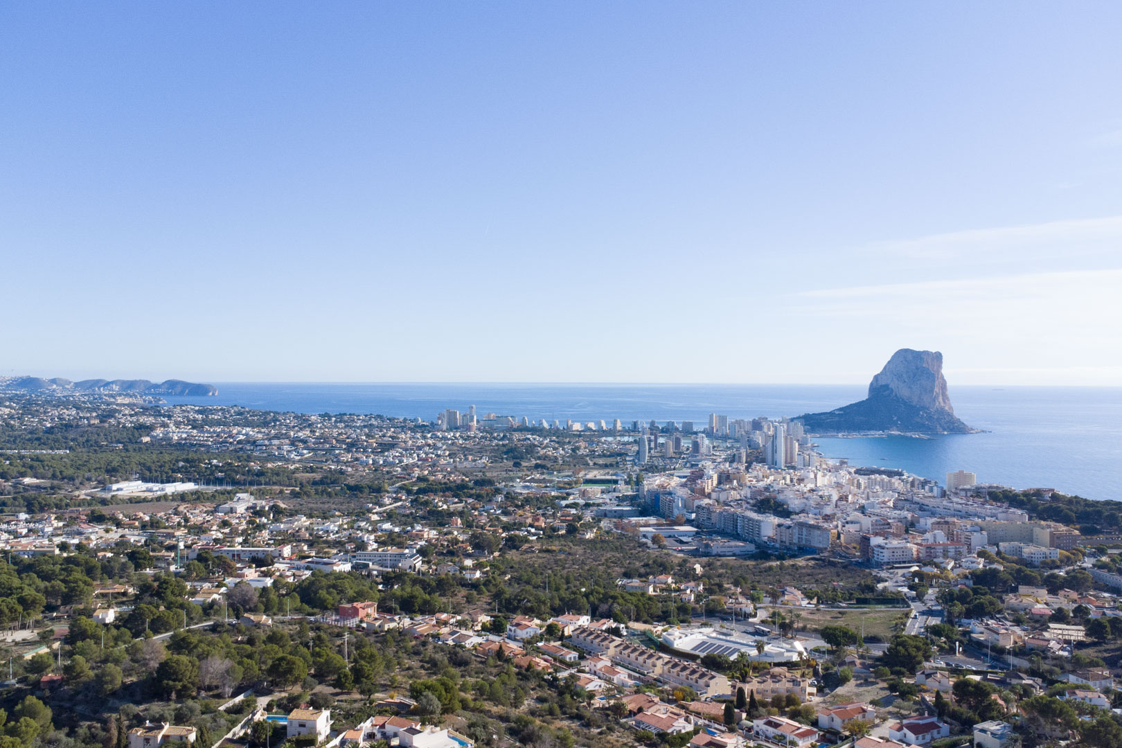 Panoramische Luftaufnahme der Küste von Calpe mit dem Peñón de Ifach, der Skyline der Stadt und dem weiten Blick über das Mittelmeer.