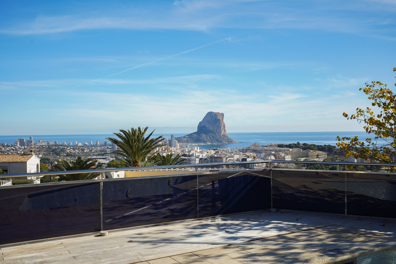 Terrasse mit Glas- und Stahlgeländer und direktem Blick auf den Peñón de Ifach, das Mittelmeer und das Stadtzentrum von Calpe.