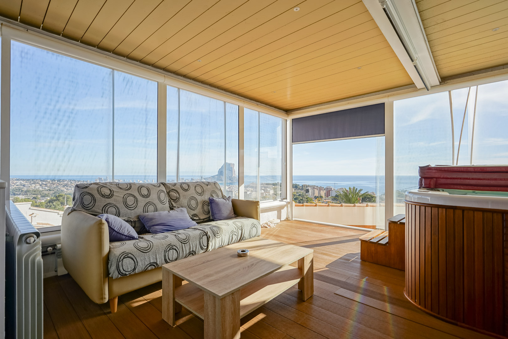 Verglaste obere Terrasse mit Whirlpool, Holzboden und Panoramablick auf den Peñón de Ifach. Ausgestattet mit Sitzbereich und bodentiefen Glasfronten.