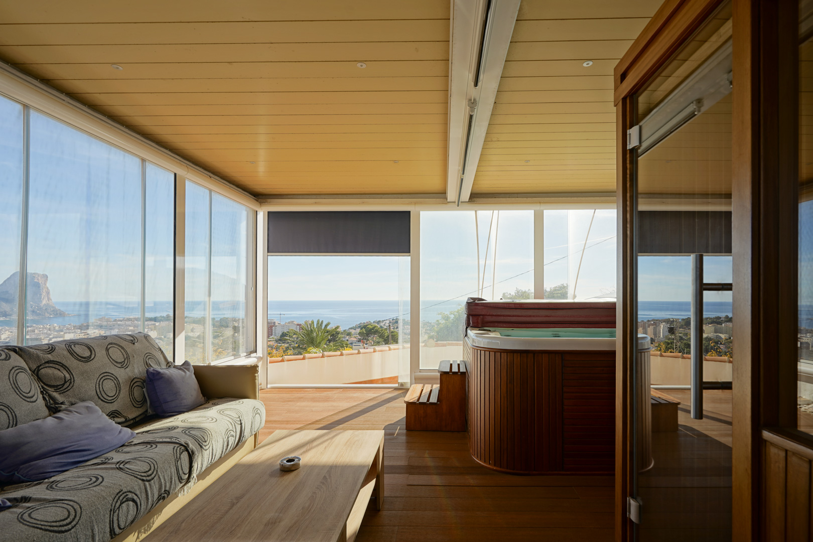 Verglaste Terrasse mit holzverkleidetem Whirlpool, Loungebereich und Panoramablick auf den Peñón de Ifach. Ausgestattet mit Holzboden und Decke mit Einbaustrahlern.