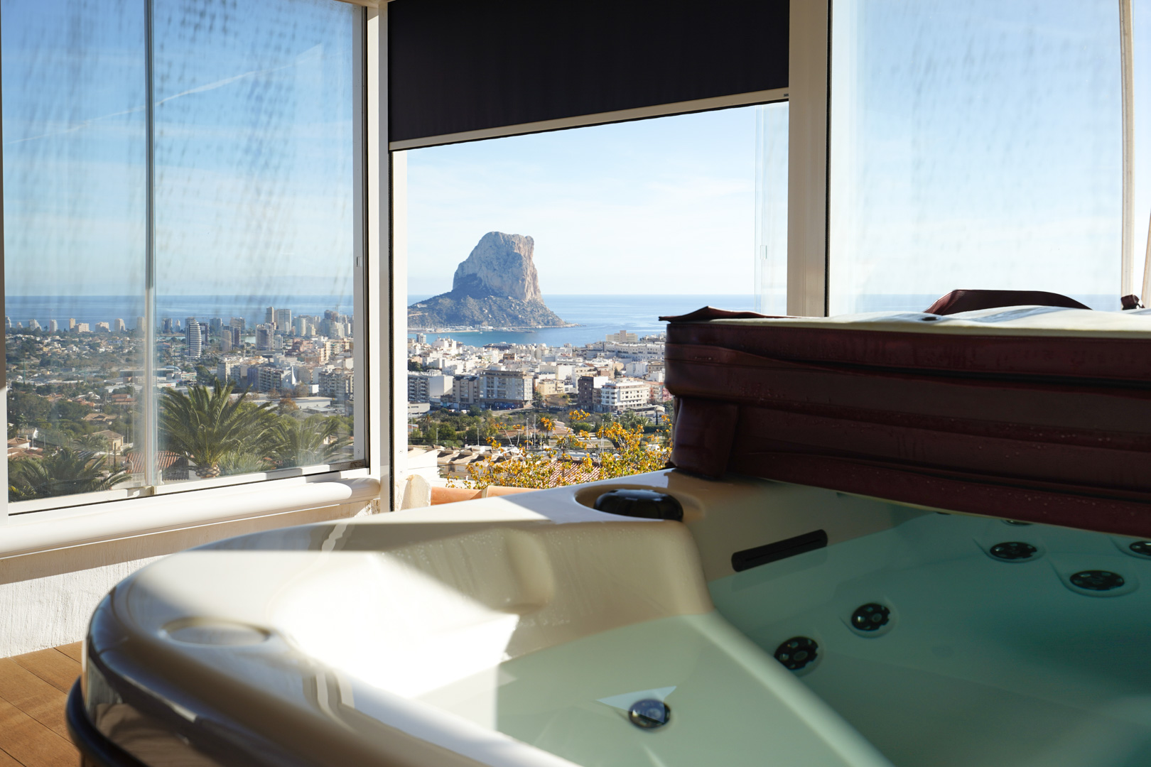 Whirlpool-Bereich auf der oberen Ebene mit Glasverkleidung und Panoramablick auf den Peñón de Ifach, die Skyline von Calpe und das Mittelmeer.