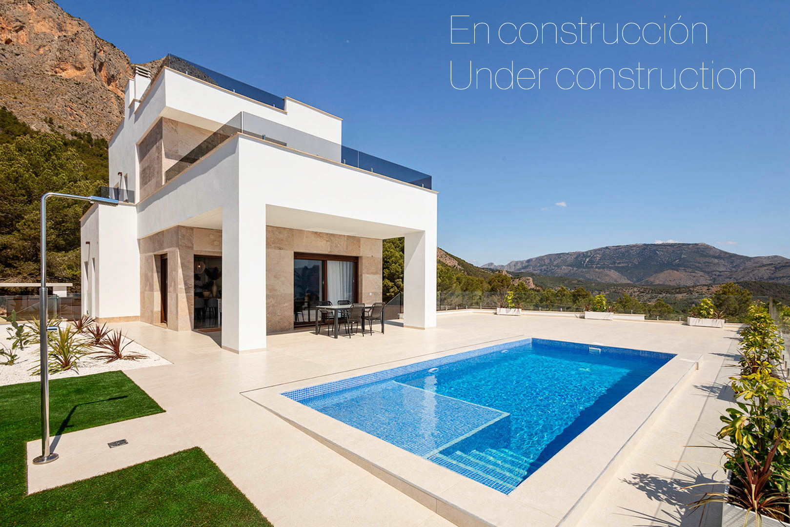 Moderne Villa mit privatem Pool, großzügigen Feinsteinzeug-Terrassen und Natursteinfassade mit Panoramablick auf die umliegenden Berge.
