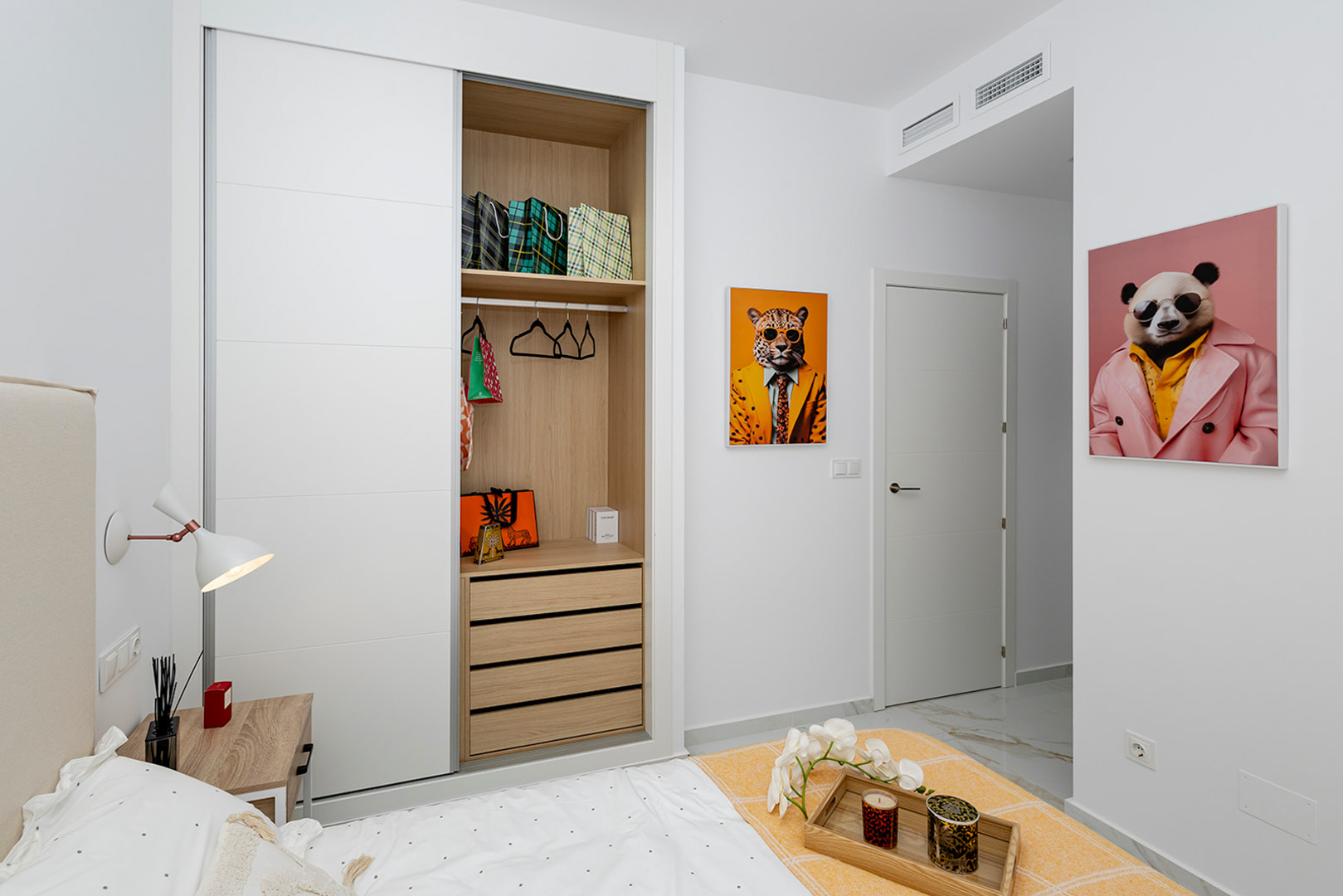Schlafzimmer mit Einbauschrank, weißen Schiebetüren und Holzinterieur. Ausgestattet mit Böden in Marmoroptik und einer zentralen Klimaanlage.