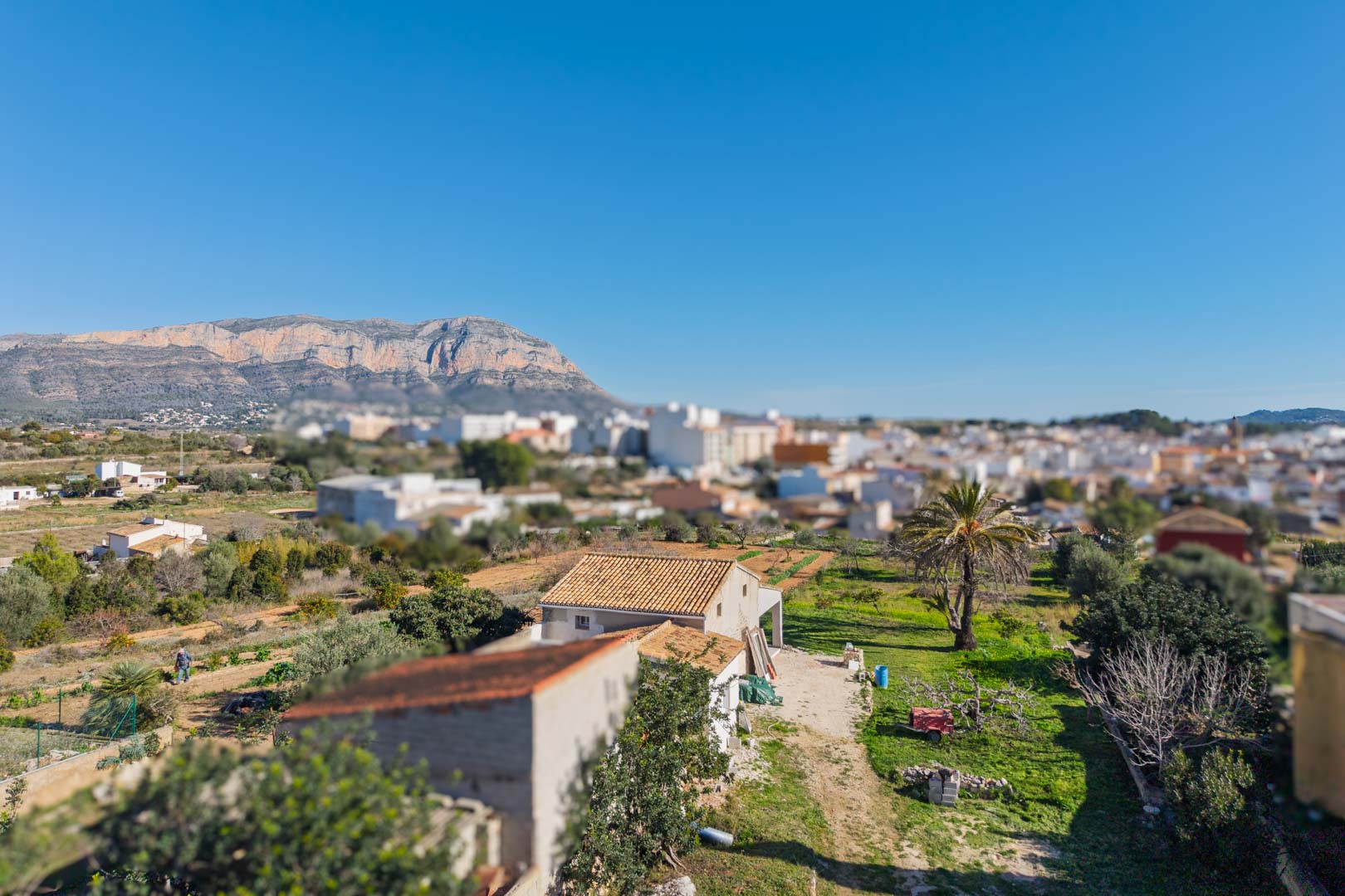 Panoramablick auf das Anwesen mit dem Montgó-Massiv im Hintergrund, der die Weitläufigkeit des Grundstücks und die Nähe zum Dorf Gata de Gorgos zeigt.