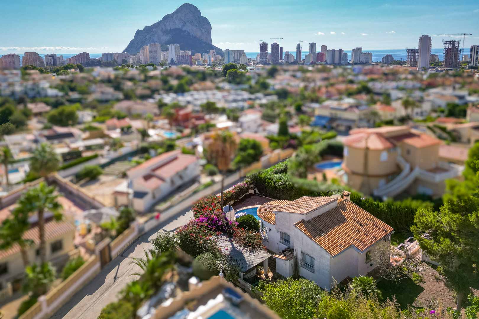 Erhöhte Ansicht der Villa mit privatem Pool und Garten, die einen weiten Panoramablick auf den Peñón de Ifach und die Skyline von Calpe bietet.