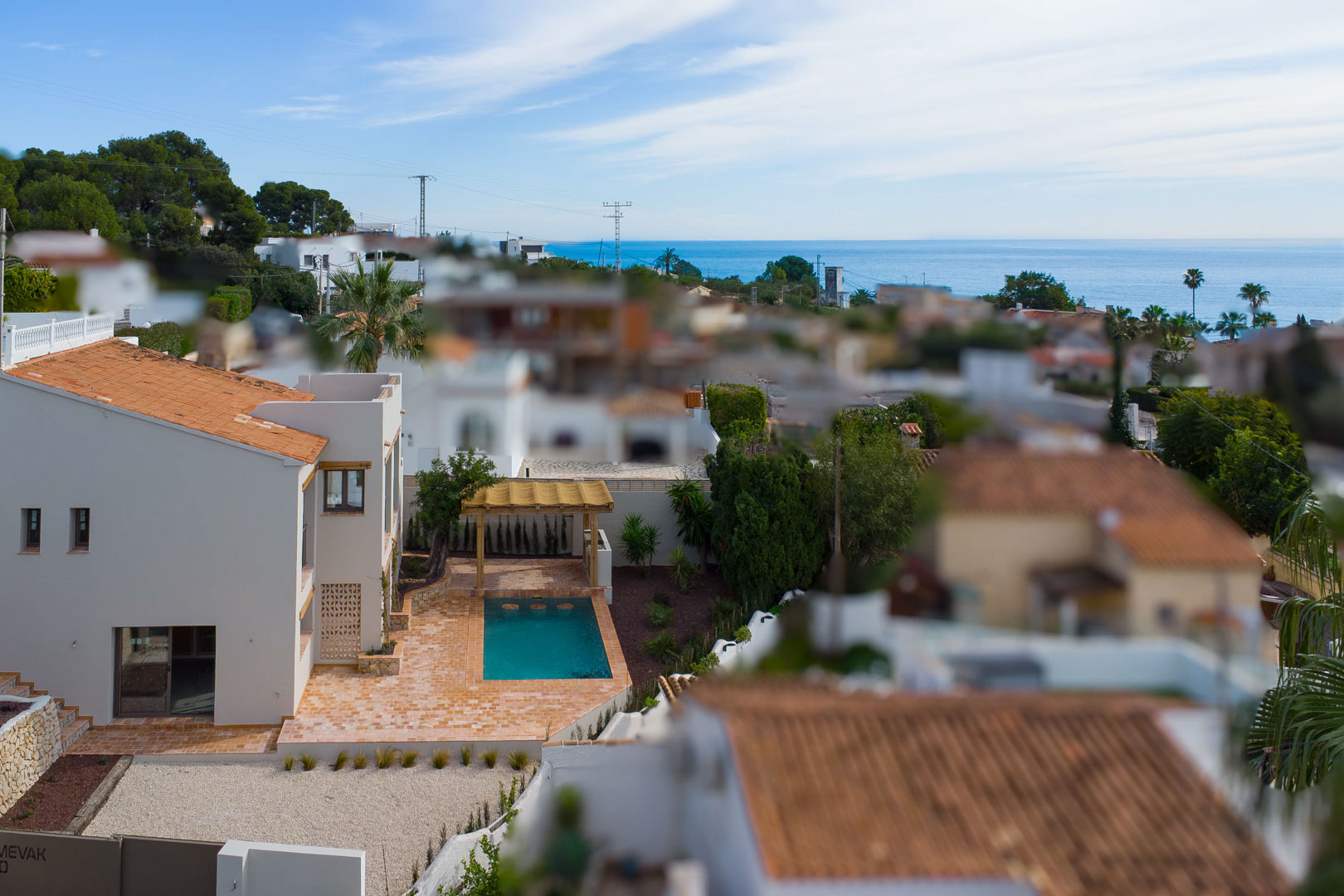 Erhöhte Ansicht der Villa mit privatem Pool, Terrakotta-Terrasse und Holzpergola, die einen weiten Blick auf das Mittelmeer und die Umgebung bietet.
