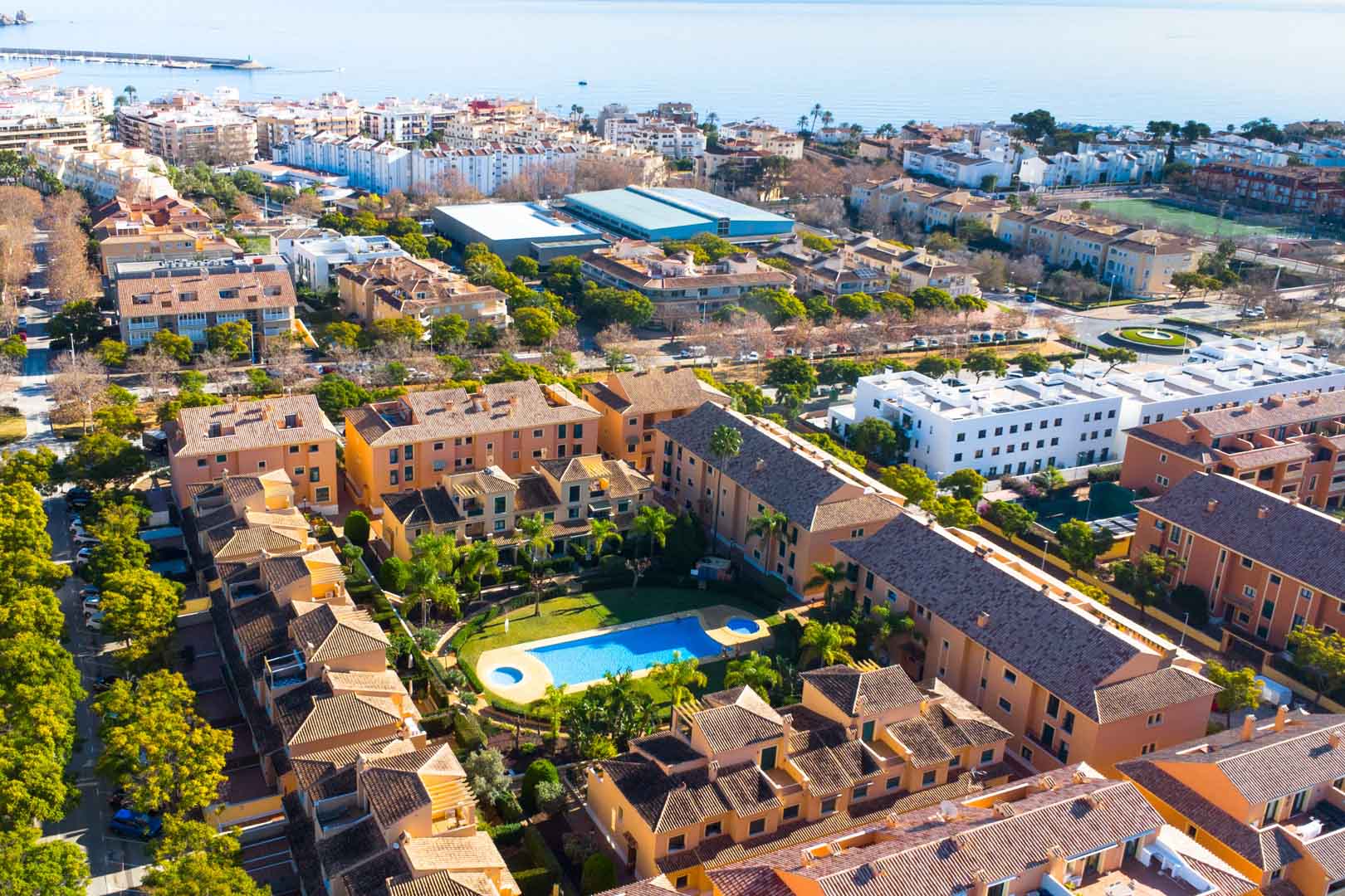 Luftaufnahme der Wohnanlage Floridamar in Jávea mit Blick auf den zentralen Pool, die Gartenanlagen und die unmittelbare Nähe zum Mittelmeer.