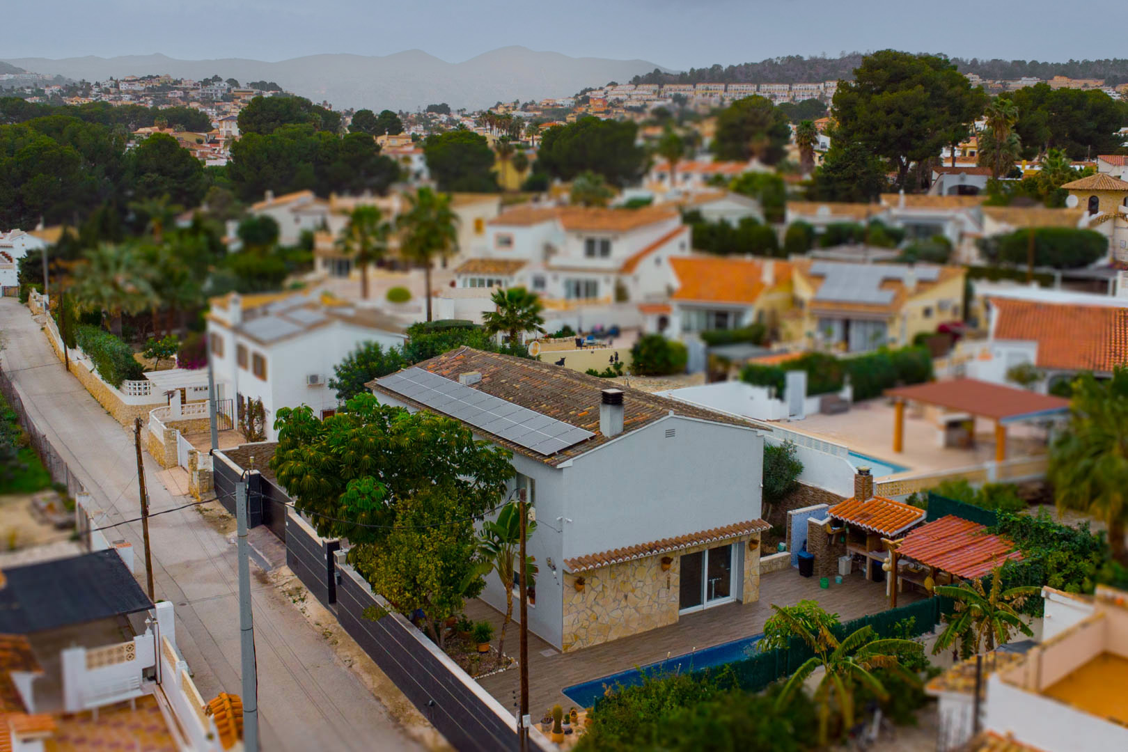 Luftaufnahme der Villa mit Photovoltaikanlage, privatem Pool und Außenküche in der ruhigen Wohngegend Carrio in Calpe.