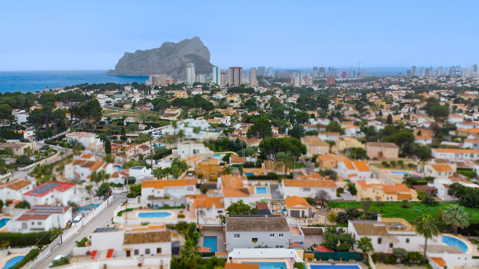 Panorama-Luftaufnahme des Wohngebiets Carrio in Calpe mit Blick auf den markanten Peñón de Ifach und das Mittelmeer am Horizont.