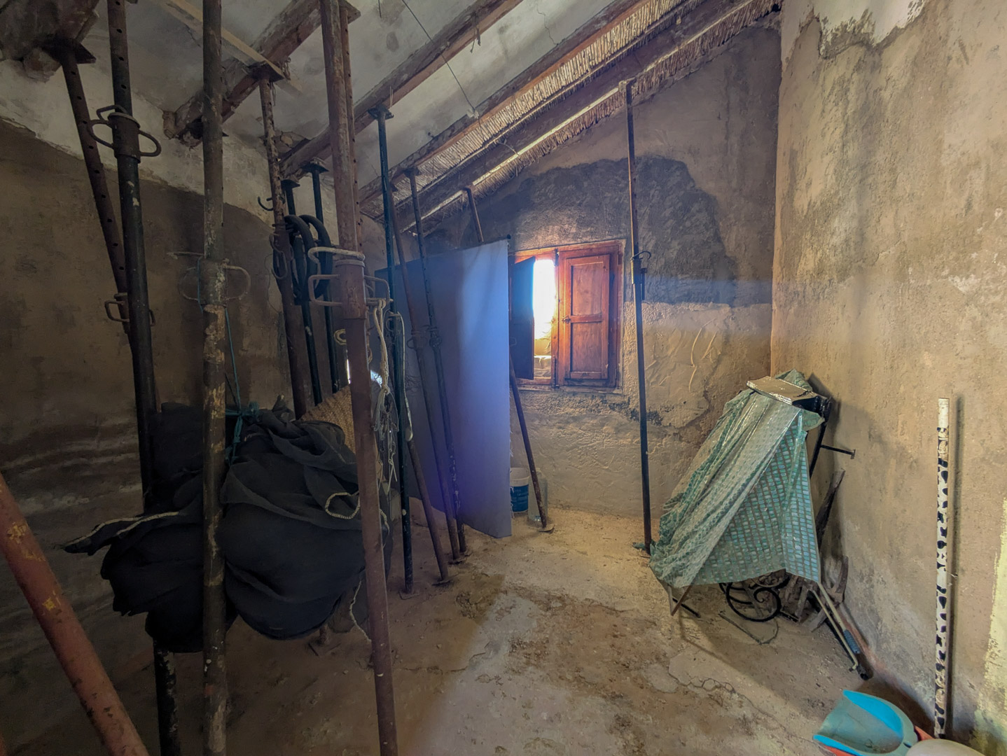 Innenraum mit traditionellen Schilfrohr- und Holzbalkendecken, die zur statischen Sicherung während der Sanierung mit Metallstützen unterbaut sind.