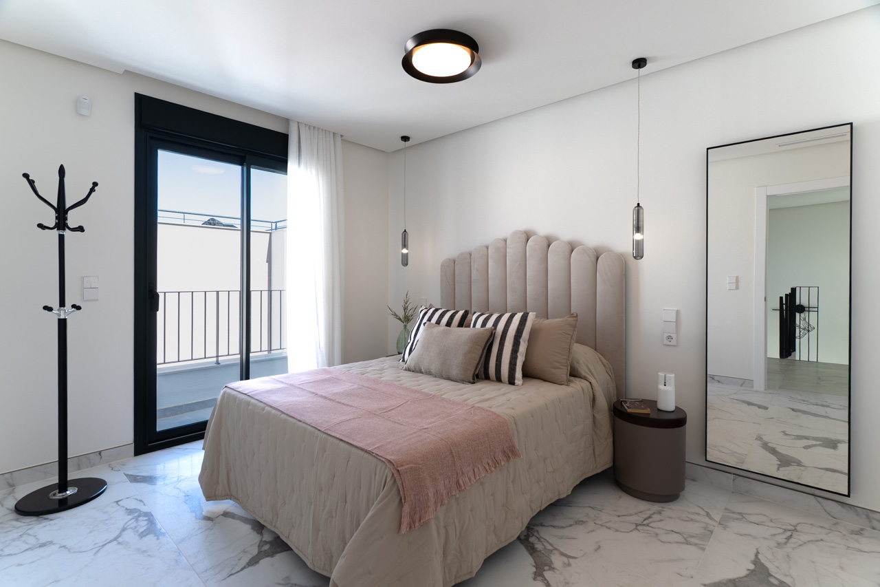 Doppelzimmer mit Feinsteinzeugboden in Marmoroptik, gepolstertem Kopfteil und direktem Zugang zur privaten Terrasse durch schwarze Schiebetüren.