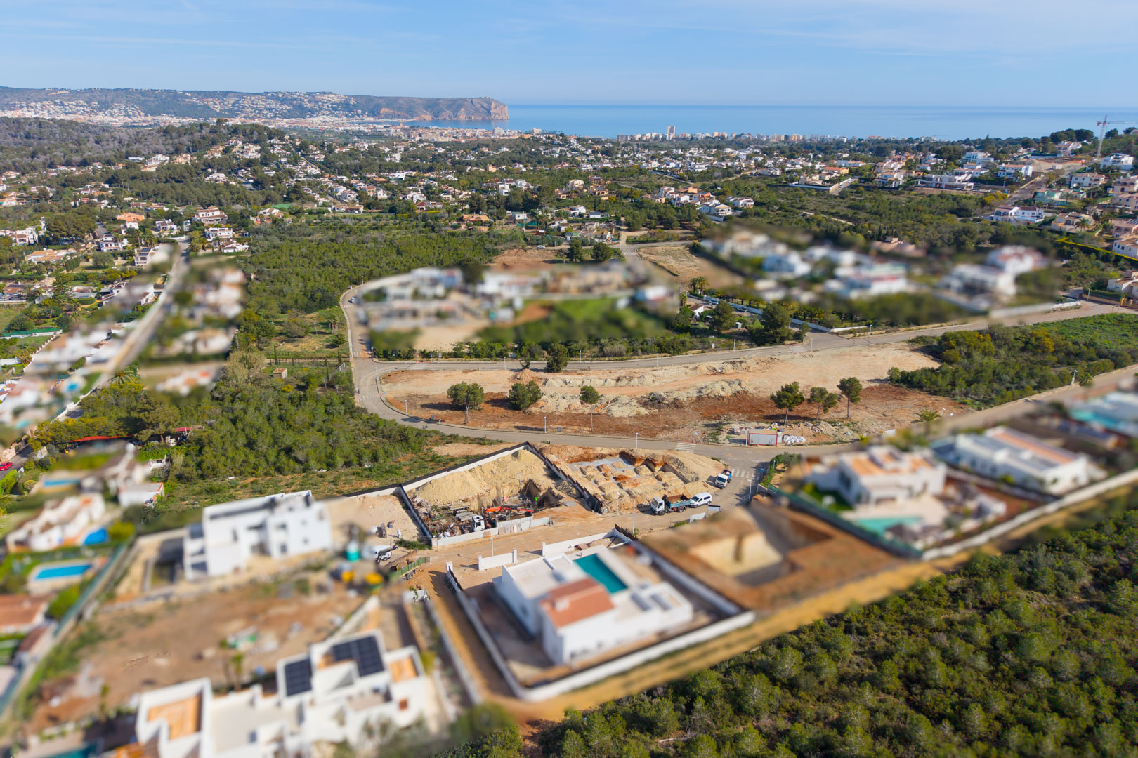Luftaufnahme des Baugrundstücks in Valsol, Jávea, die den Fortschritt der Fundamentarbeiten und den weiten Blick auf das Mittelmeer zeigt.