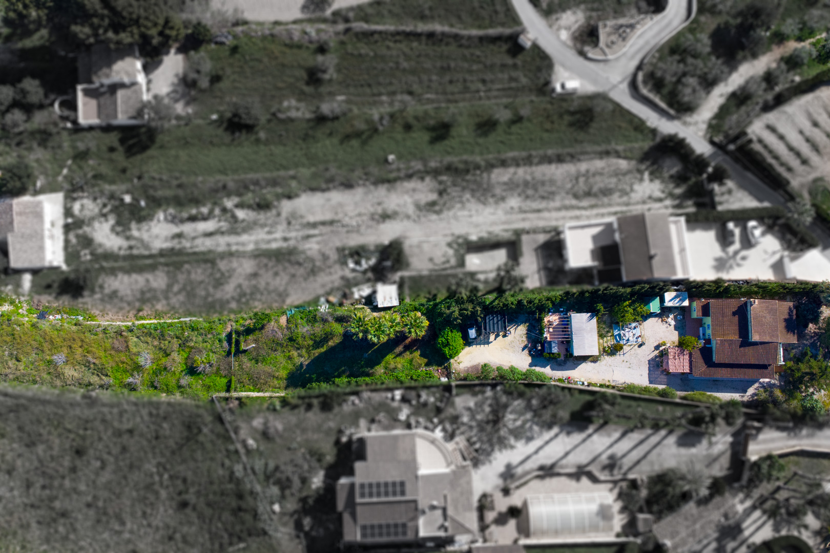 Luftaufnahme der Finca mit Darstellung der Hauptvilla, des Nebengebäudes und des weitläufigen rustikalen Grundstücks in erhöhter Lage über dem Tal.