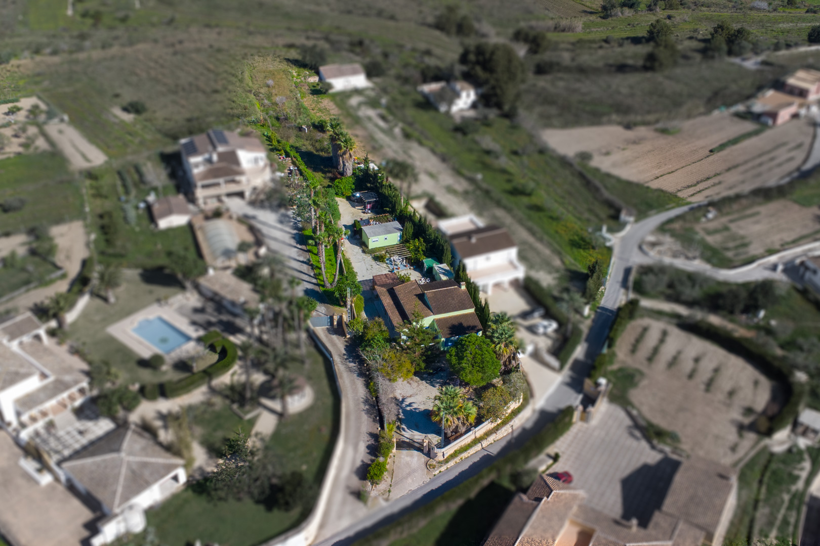 Luftaufnahme des 2.800 m2 großen rustikalen Grundstücks mit der Hauptvilla, dem separaten Fertighaus und dem weitläufigen, mit Palmen bepflanzten Gelände.