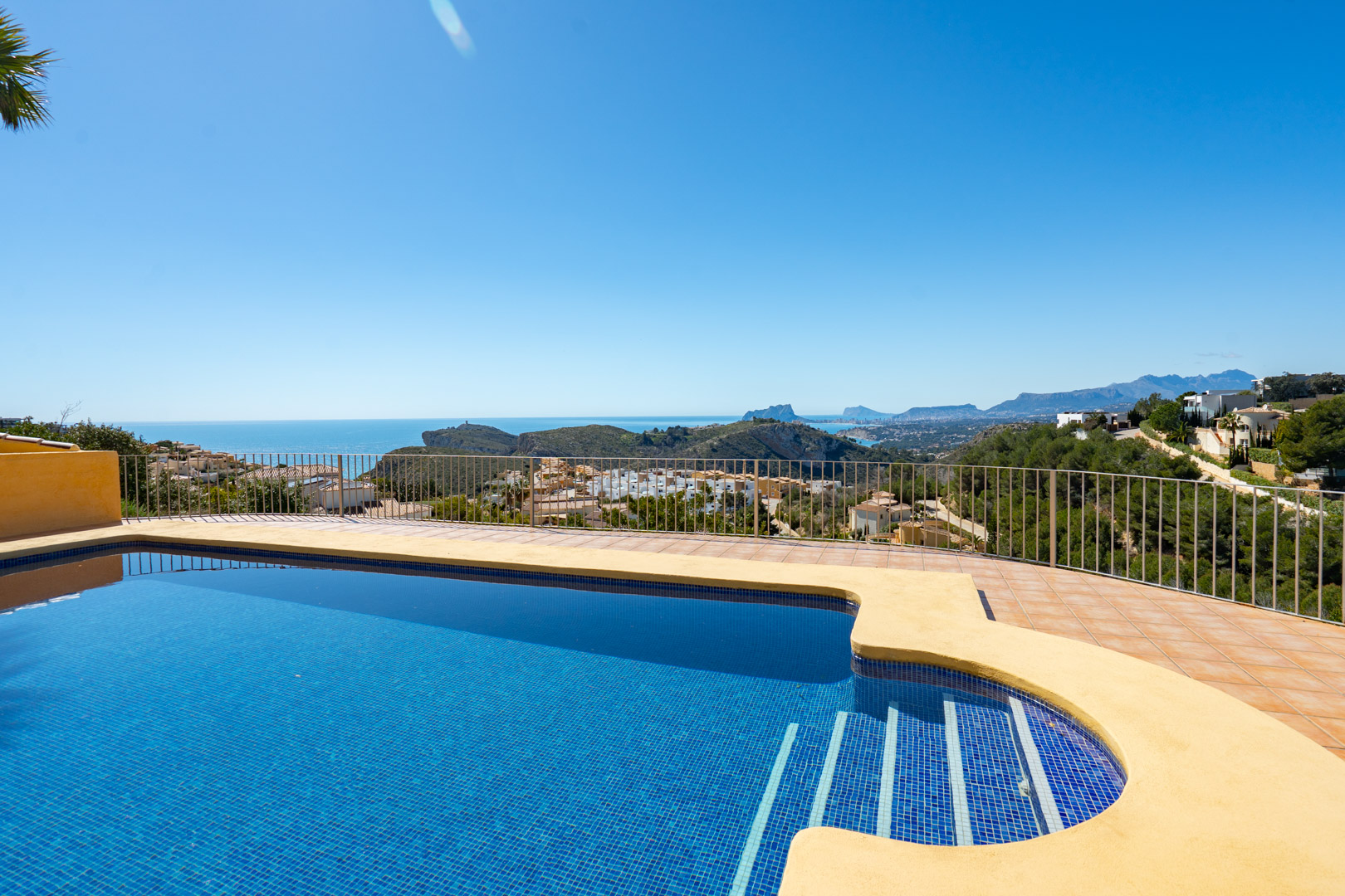 Terrasse mit blau gefliestem Pool und Panoramablick auf das Mittelmeer, die Küste von Calpe mit dem Peñón de Ifach und das Bernia-Gebirge.