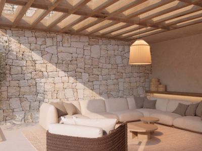 Außenlounge mit Natursteinwand, Holzpergola und großem Ecksofa. Die Hängeleuchte und moderne Möbel schaffen eine einladende Atmosphäre.