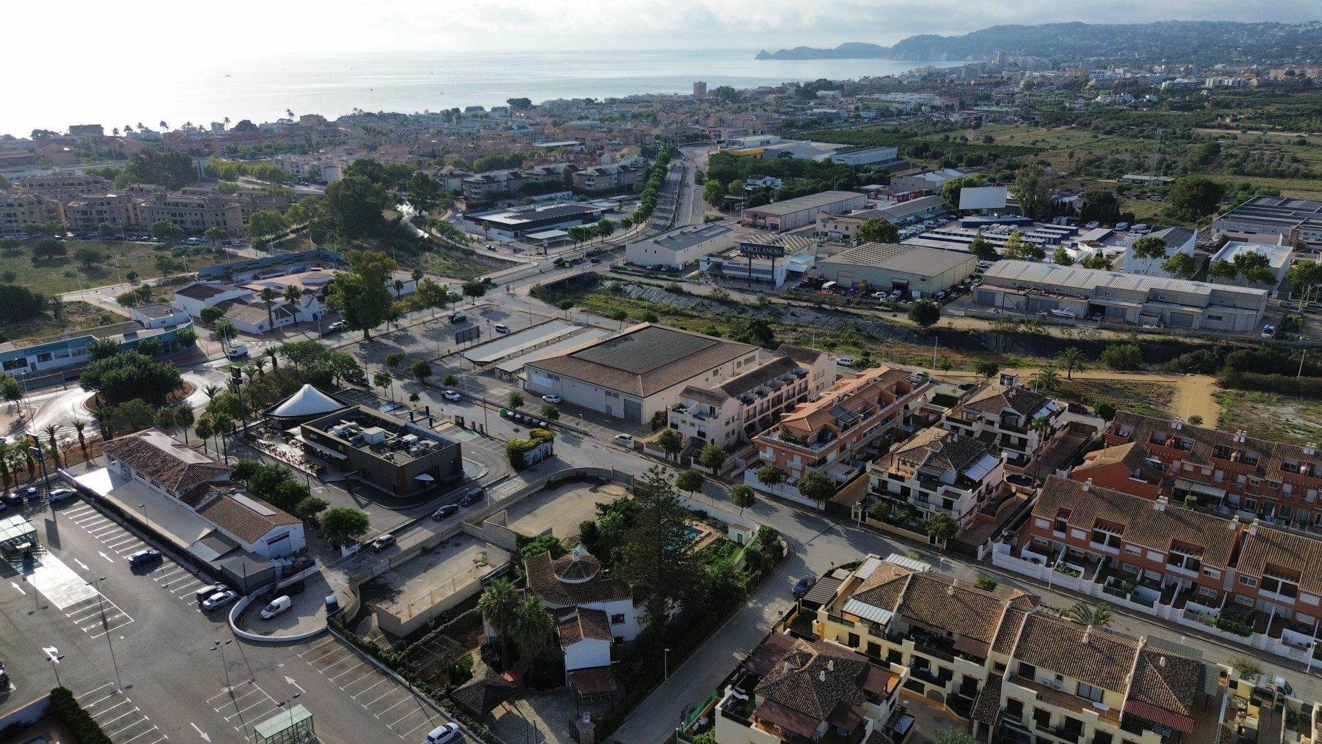 Luftaufnahme von Jávea mit Wohn- und Geschäftsgebäuden und dem Mittelmeer im Hintergrund.