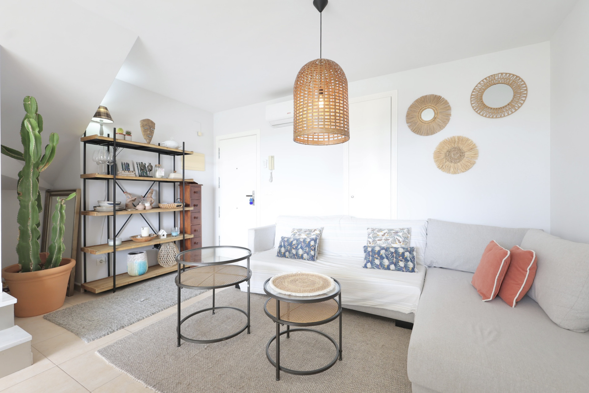Helles Wohnzimmer mit Holzregal, modularem Sofa und Designer-Beistelltischen.