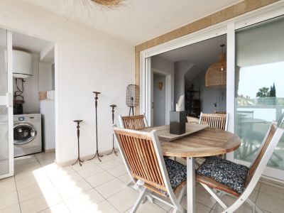 Terrasse mit rundem Holztisch und passenden Stühlen, mit Zugang zu einer Waschküche.