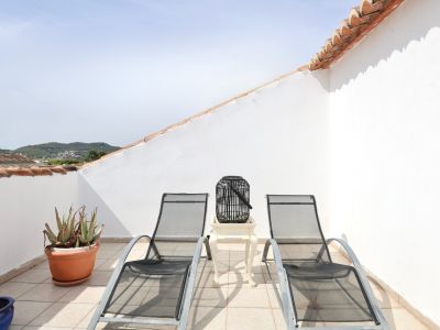 Terrasse mit zwei Sonnenliegen aus Metall, Beistelltisch und Bergblick.