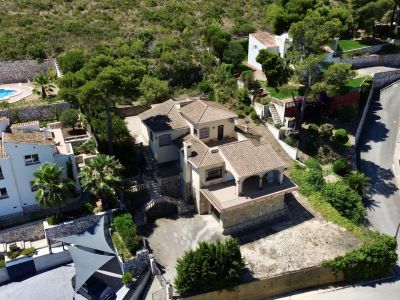 Luftaufnahme der mehrstöckigen Villa mit traditionellen Ziegeldächern, mehreren Terrassen und Hangbereichen, eingebettet in mediterrane Vegetation.