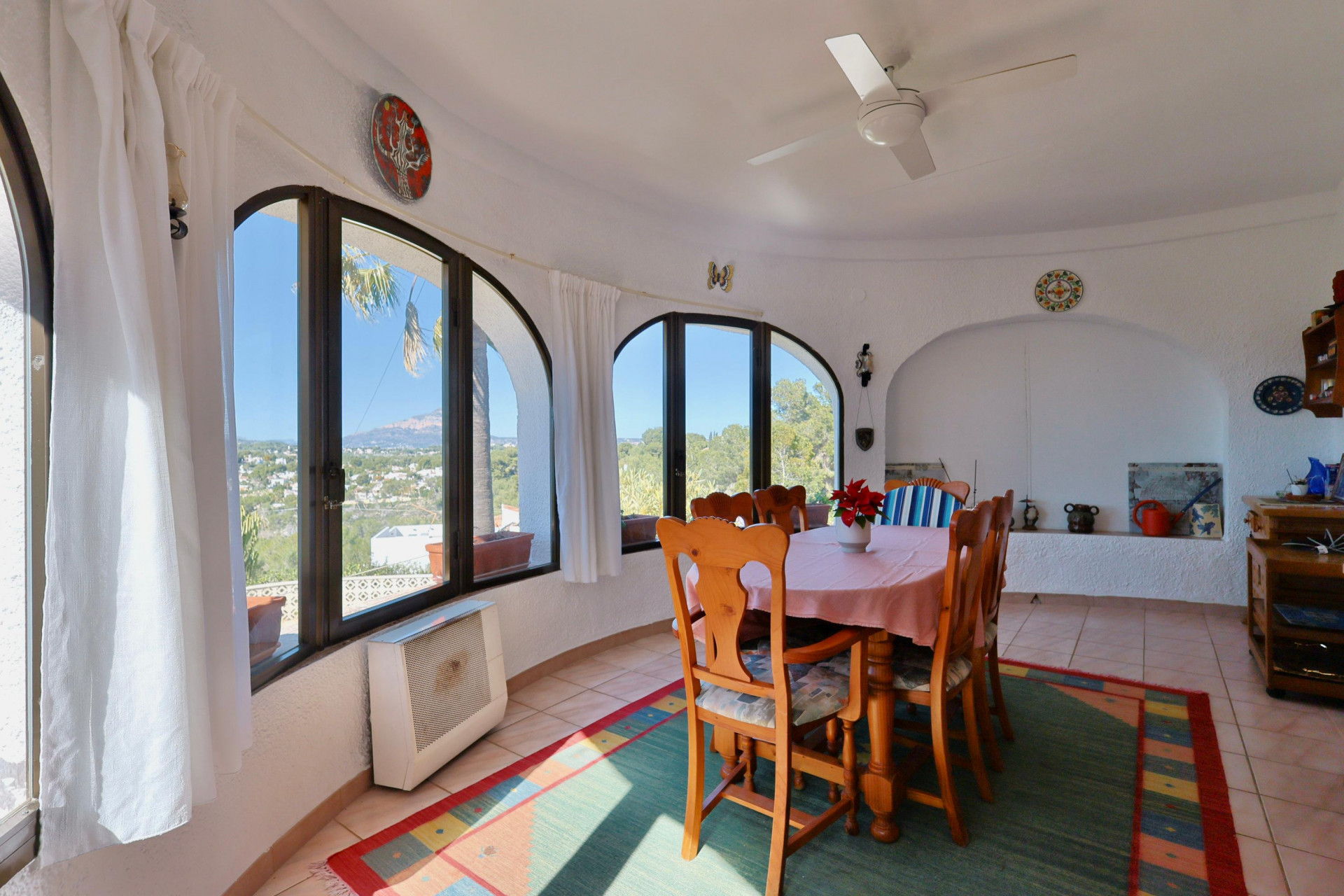 Heller Essbereich mit Bogenfenstern und Panoramablick auf die Landschaft von Jávea.