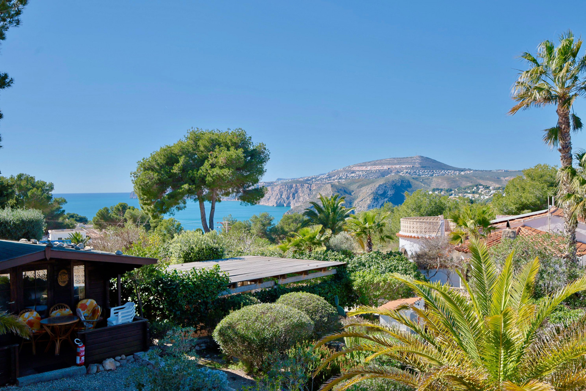 Panoramablick auf Jávea mit Holzhütte und üppigem Grün.