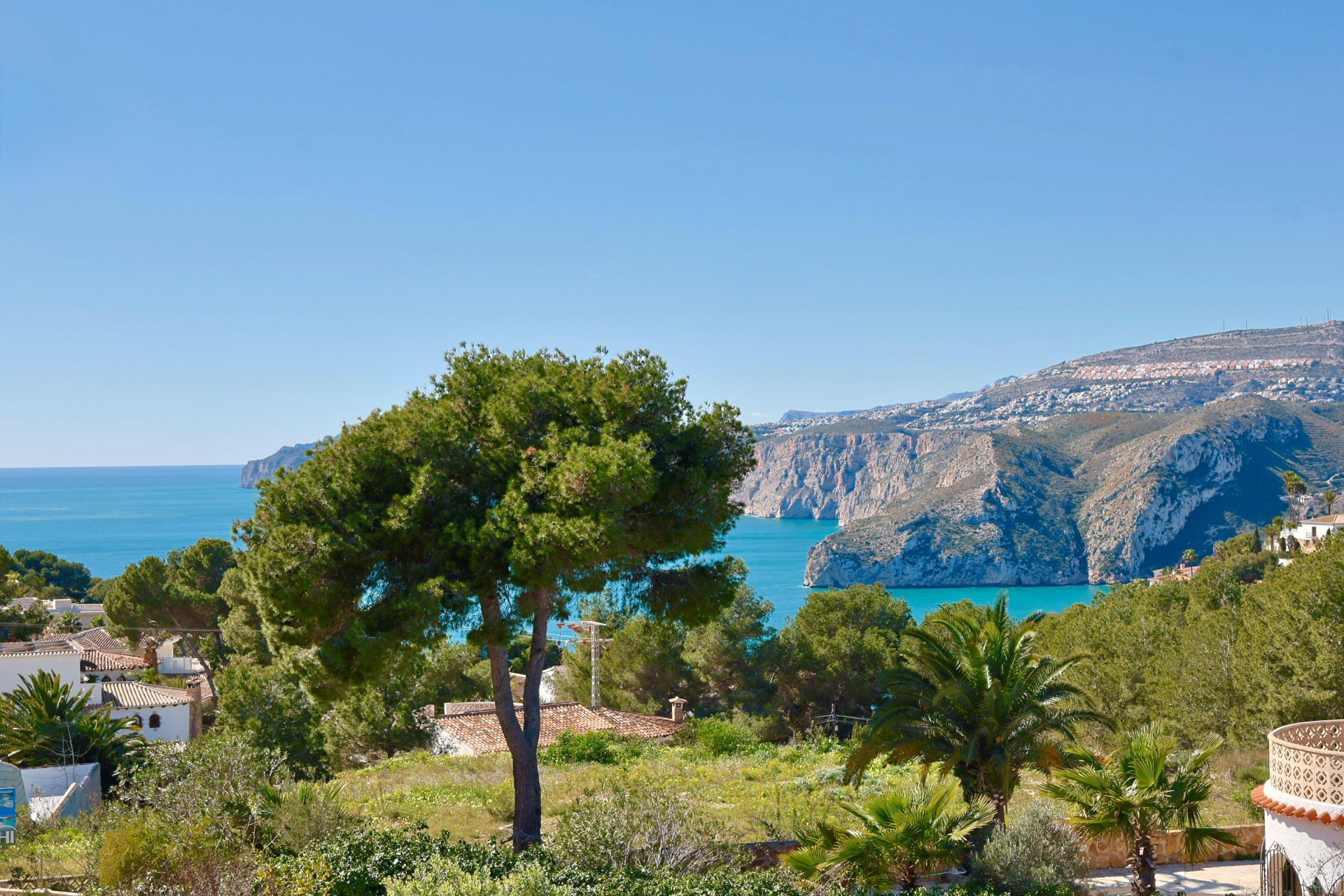 Panoramablick auf Jávea mit üppigem Grün und dem Mittelmeer im Hintergrund.