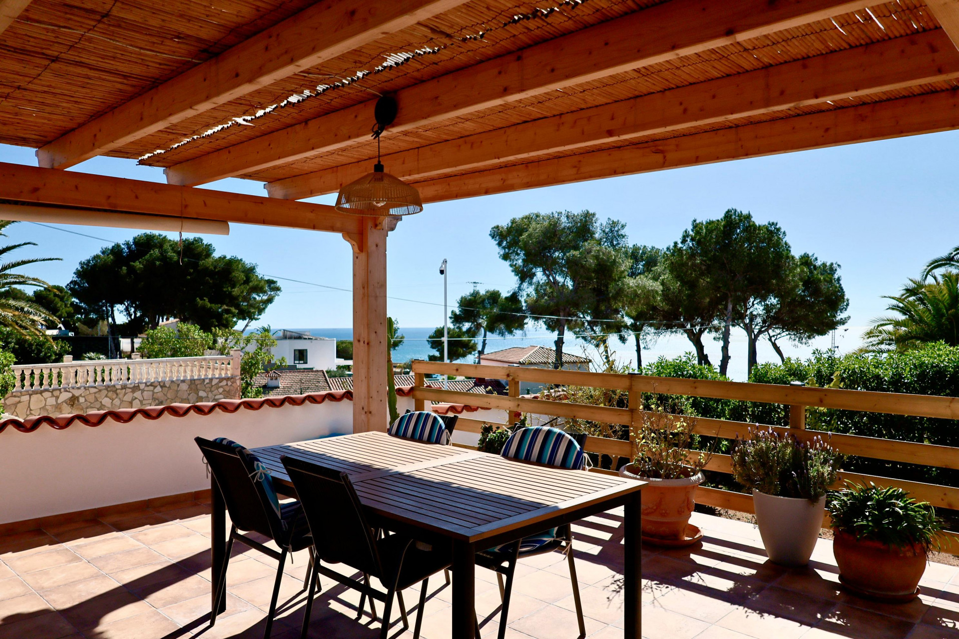 Überdachte Terrasse mit Esstisch und Meerblick in Jávea.