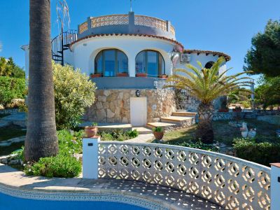 Außenansicht der Villa mit Pool und Steinfassade, umgeben von mediterranen Gärten.