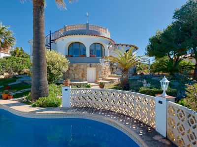 Blick auf den Pool mit Gittergeländer und Steinfassade der Villa in Jávea.