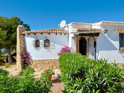 Fassade einer mediterranen Villa mit Steindetails, Dachziegeln und Zierbeschlägen.