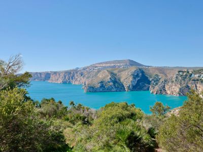 Panoramablick auf die felsige Küstenlinie und das Mittelmeer von der üppigen Vegetation Jáveas aus.